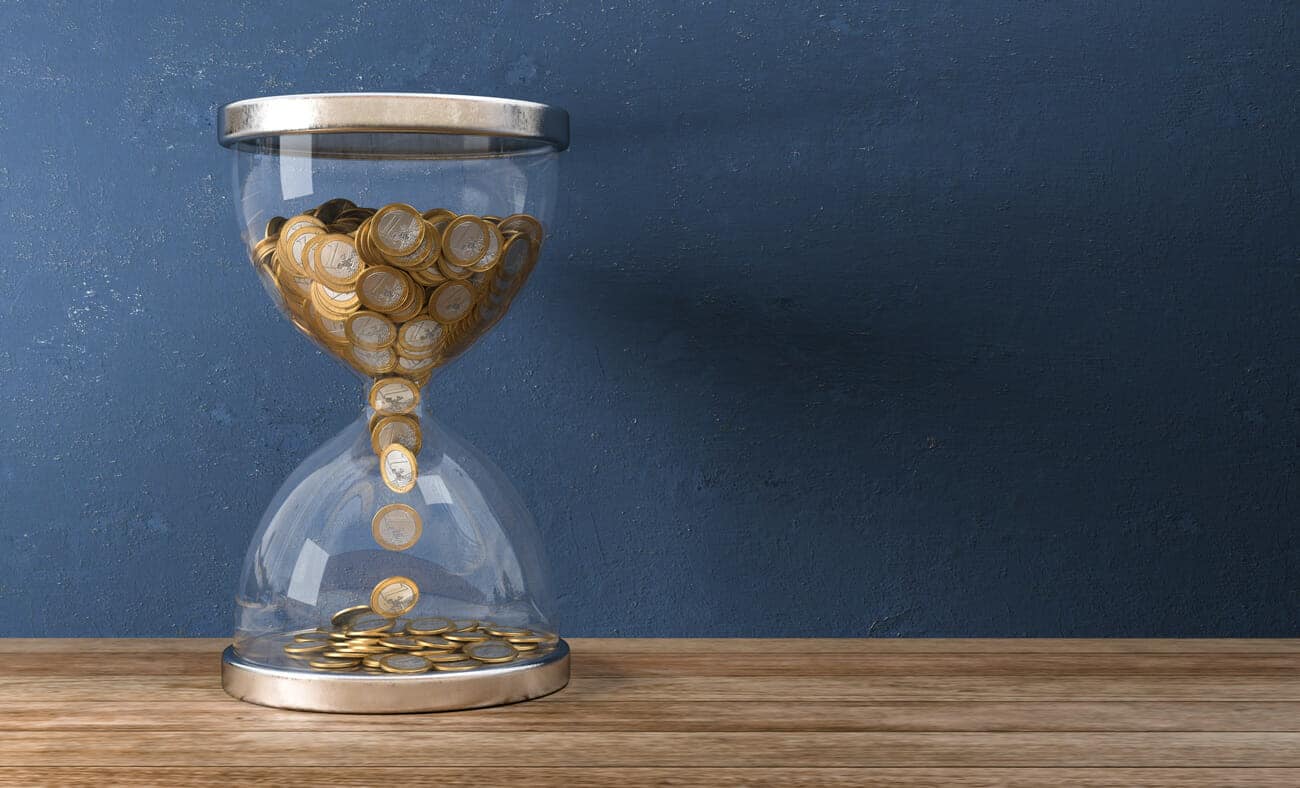 Sanduhr mit Geldmünzen anstelle von Sand